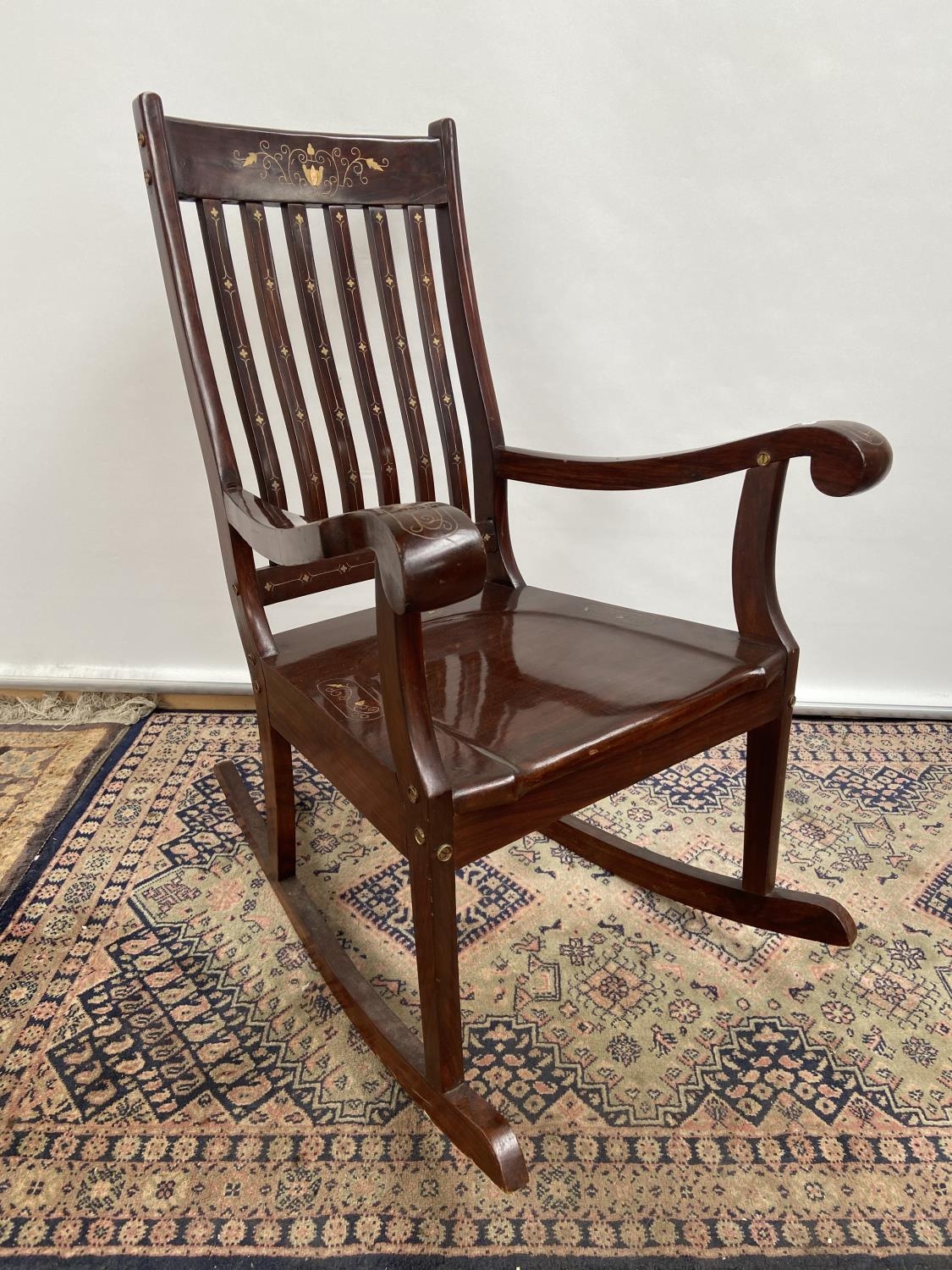 A Hardwood and brass inlaid rocking arm chair. [80x50x40cm] Originally from Saudi Arabia.