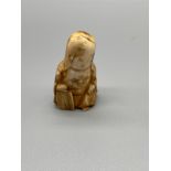 A Japanese Meiji period hand carved netsuke of an elderly scholar. [4.5cm in height]