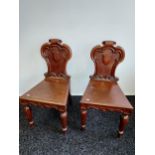 A Pair of 19th century dark wood church chairs. Detailing relief scroll and shield carvings.