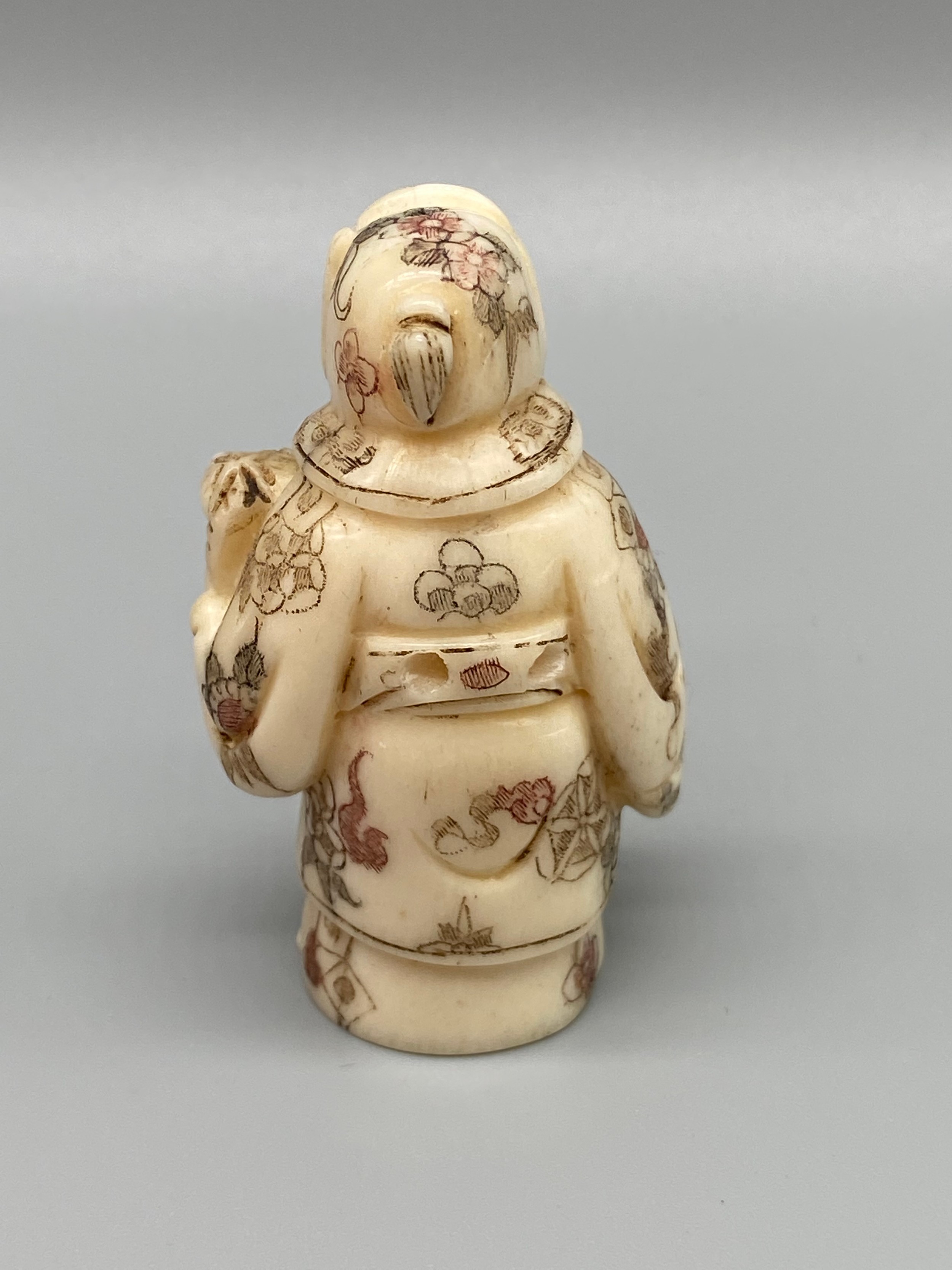 An early 20th century Japanese hand carved bone netsuke of a cloaked gentleman holding a sword and - Image 5 of 5