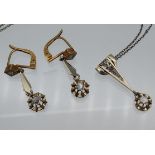 An Art Deco design Gold and diamond pendant and matching earrings. Comes with a white metal