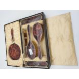 An Antique cased Birmingham silver and tortoise shell dressing table mirror and brush set.