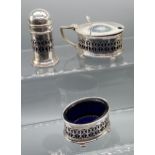 A Birmingham silver three piece condiment set. All fitted with blue glass liners. Produced by Docker