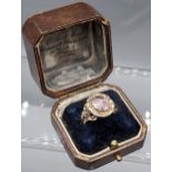 An Antique 19th century ornate ladies ring set with a pale purple stone. [Ring size L] [5.22 Grams]