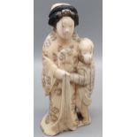 A nice example of a Japanese hand carved bone figure of a geisha cuddling a monkey figure. [12cm