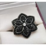 A Nice example of a ladies 925 silver ring in the form of a flower detailing black stones with a