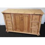 An Antique farm house pine sideboard designed with 6 drawers and two door storage area. [