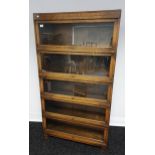 An early 20th century 5 section Barristers bookcase, designed with glass and oak lift up section