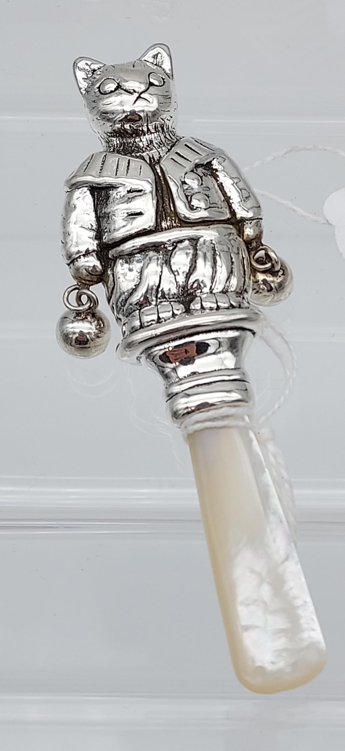 A silver baby's rattle with mother of pearl handle [14.79g]