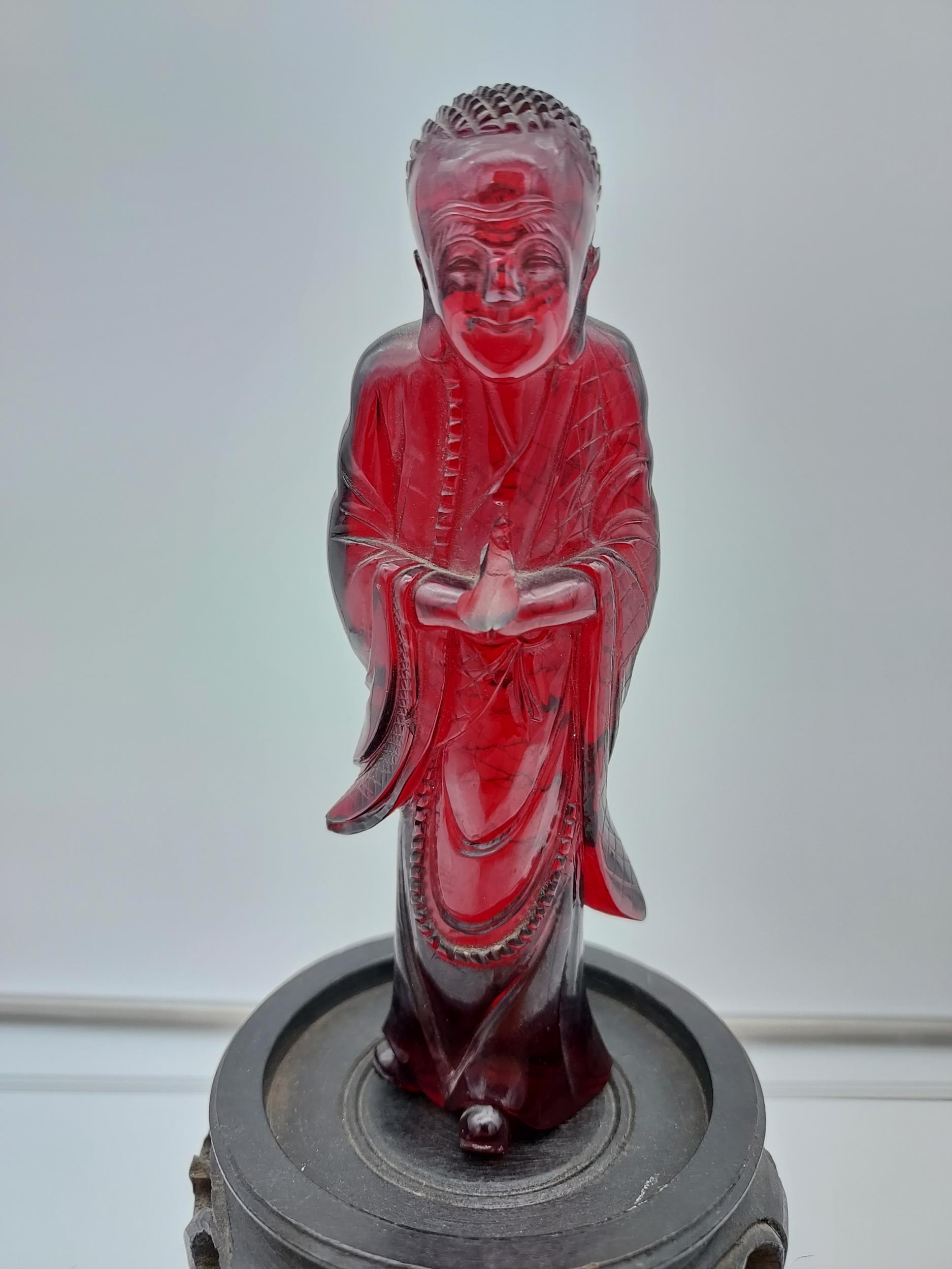 A 19TH Century Chinese hand carved Cherry amber buddha figurine with a hand carved wooden base. [ - Image 3 of 10