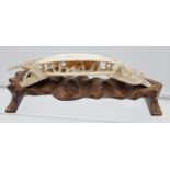 Antique Chinese hand carved ivory sculpture sat upon a carved wooden stand. [18cm in length]