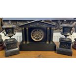 A 19th century French slate mantle clock with two matching garnitures.