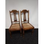 A set of four early 20th century oak dining chairs, with pierced splat back, carved floral trims