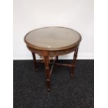 A 19th century barrel window table with glass top above a carved frieze,