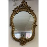 A 18th/ 19th century ornate gilt carved framed wall mirror. [97x50cm]