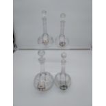 A Lot of four various antique facet cut long neck crystal decanters all with ceramic drinks