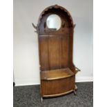 A nice example of an Art Deco oak, hall coat stand. Designed with a circular mirror, and lift up