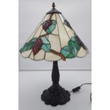 A Tiffany style table lamp. Shed designed with grapes and vines. [In a working condition] [67cm in