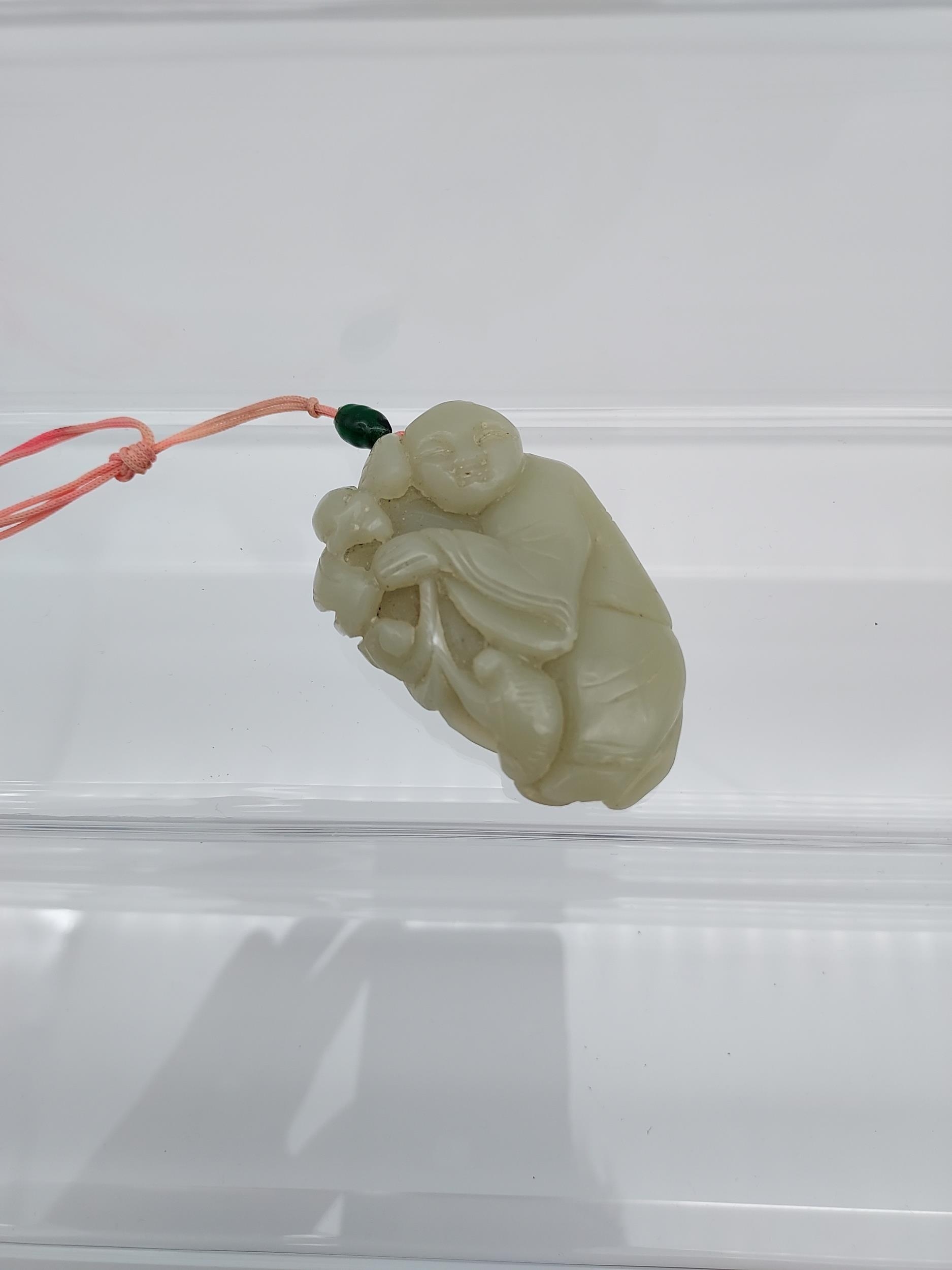 An early 20th century Chinese hand carved jade sculpture of a boy and bat. [6cm in length]