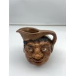 Antique pottery double face water jug in the style of Martin Brothers. 13cm in height