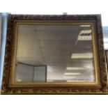 A Large impressive gilt framed and bevel edge mirror. [117x140cm]