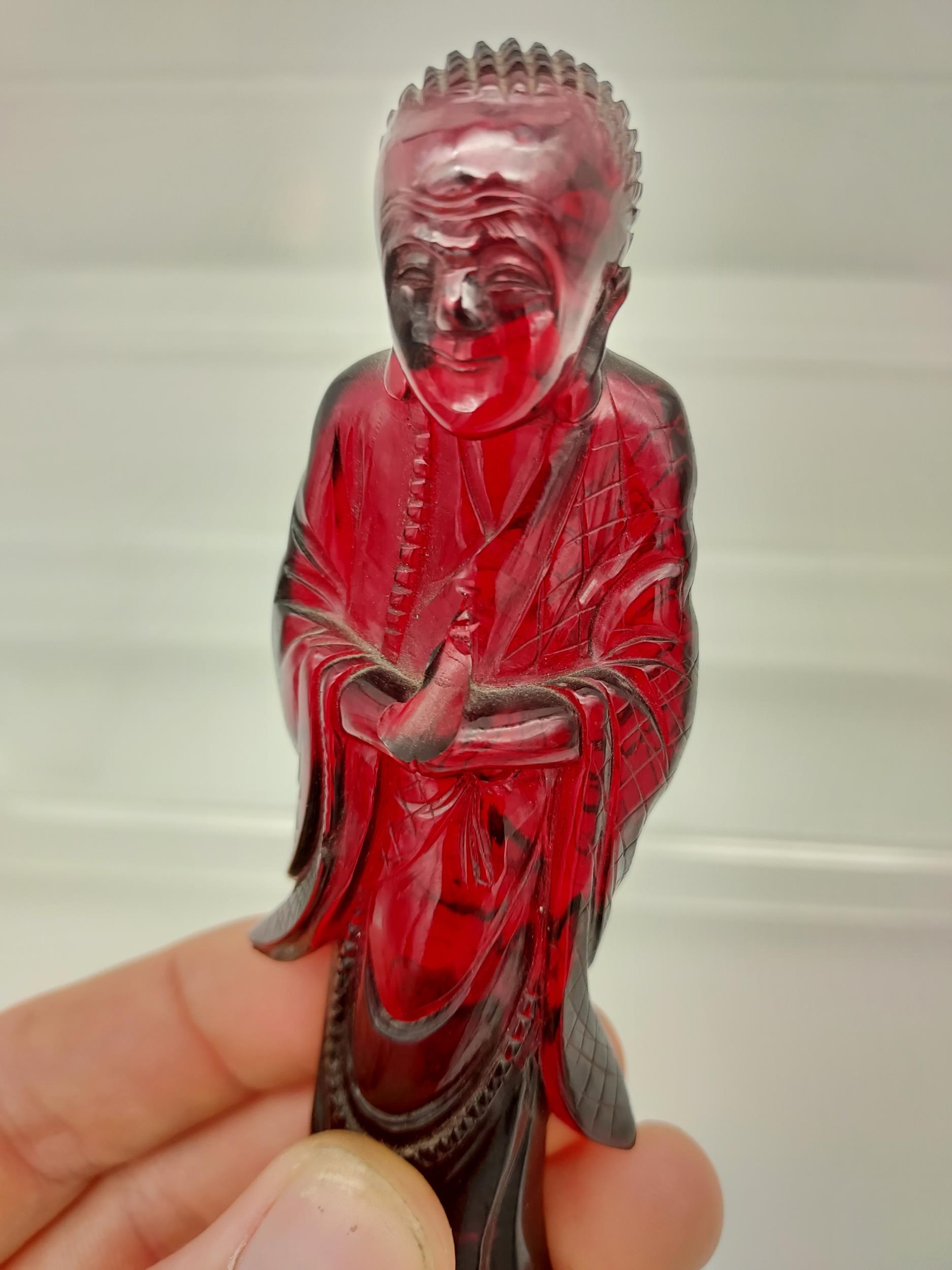 A 19TH Century Chinese hand carved Cherry amber buddha figurine with a hand carved wooden base. [ - Image 7 of 10