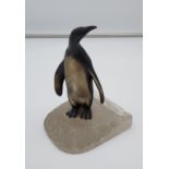 A Cold painted penguin figurine sat upon an iceberg. [12cm in height]