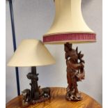 A Japanese hand carved wooden figure table lamp together with an African carved elephant table lamp