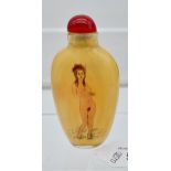 A Chinese hand painted glass perfume bottle showing two nude figures to each side.