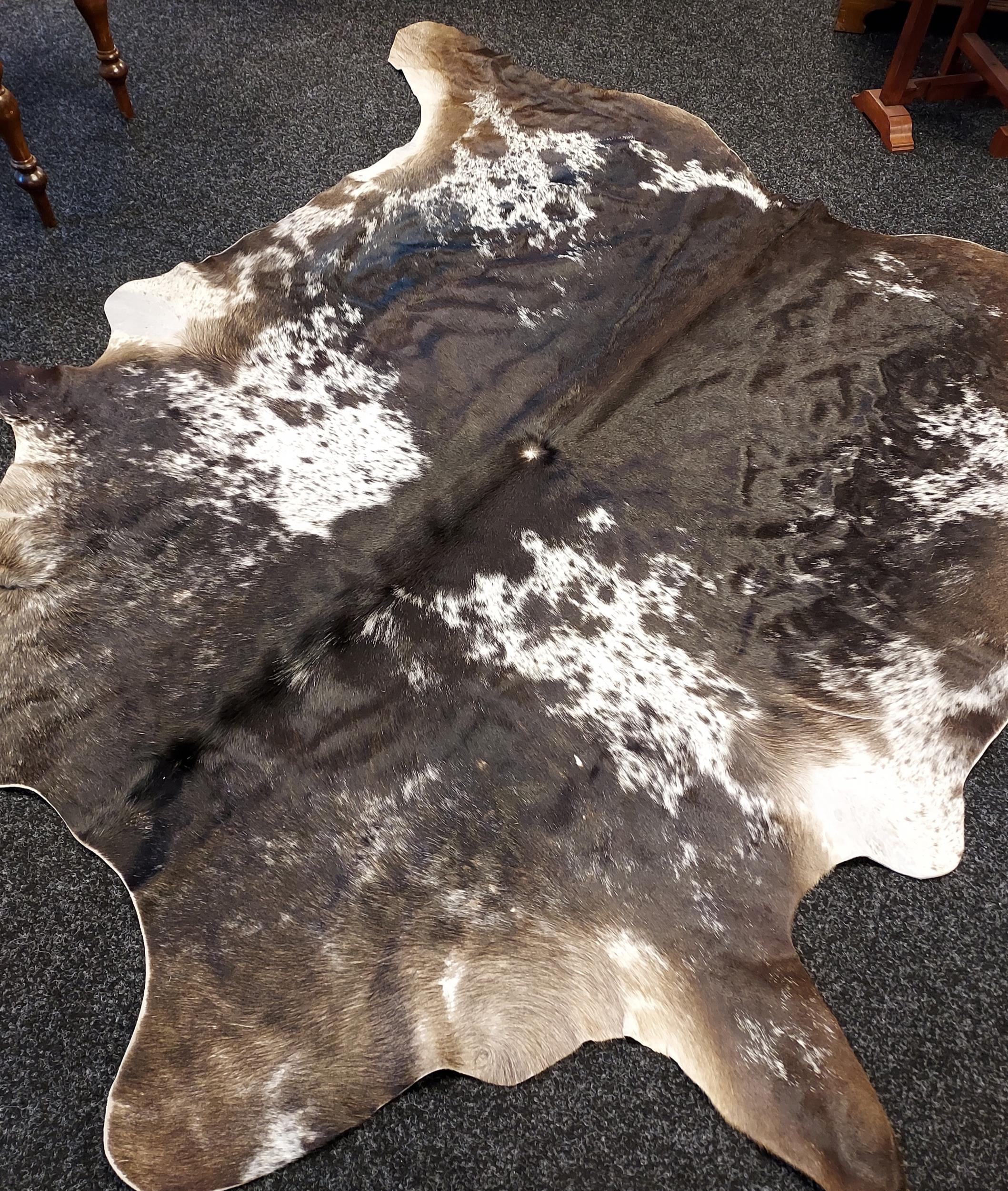 A Large cow hide rug. [220cm in length] - Image 2 of 3