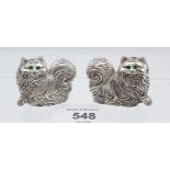 A pair of silver plated long haired cat condiments with emerald eyes