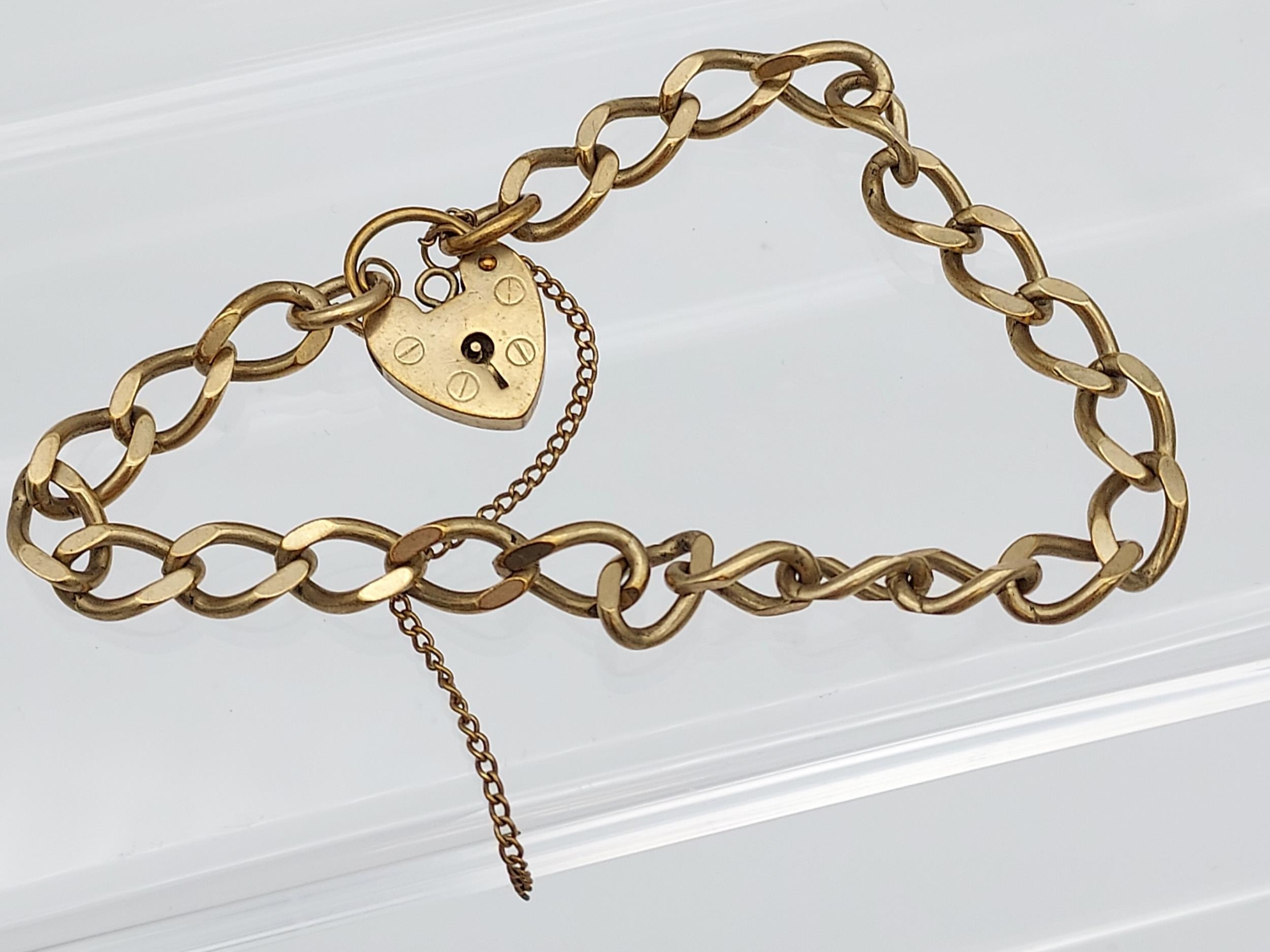 A 9ct gold curb bracelet with heart locket. [13.84grams]