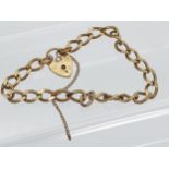 A 9ct gold curb bracelet with heart locket. [13.84grams]