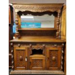 19th century oak dresser, heavily carved throughout with a green man, leaf and flower decoration,