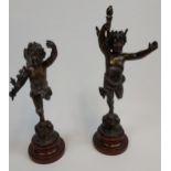 A Pair of Antique bronzed spelter cherub figurines, sat upon marble bases.