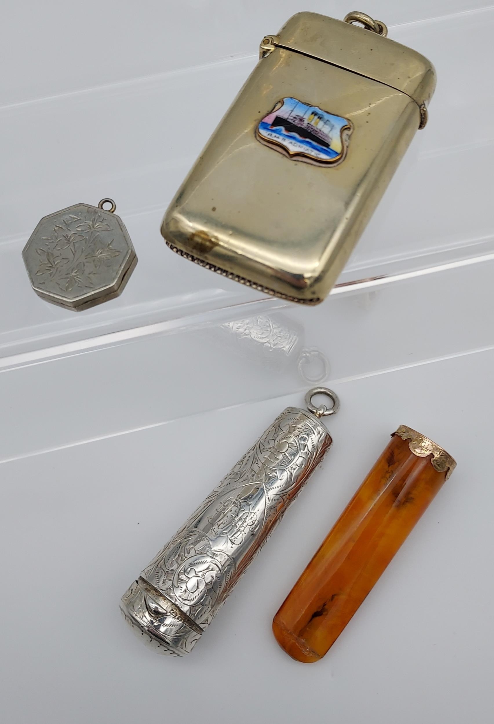 A Birmingham silver cheroot holder containing a amber and 9ct gold cheroot, White metal locket and