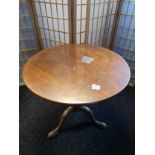 A Mahogany tripod supper table, circular tilt top on a baluster column and tripod base ending in