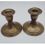 A Pair of weighted Sterling silver candle sticks [8.5cm in height]