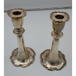 A Pair of silver ornate candle sticks. [weighted] [20cm in height]