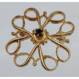 A 9ct gold brooch with a single sapphire stone. [1.8grams] [2.5cm in diameter]