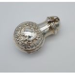 An ornate Birmingham silver cased perfume bottle. Encased with a glass bottle. [5cm in length]