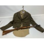 Military uniform jacket and shirt together with a replica display rifle.