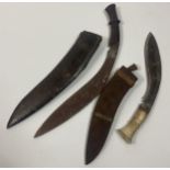 Two antique Kukri Knives with sheaths. One has a wooden handle and the other has a bone handle.