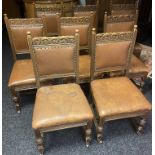Set of eight oak carved chairs with brown leather upholstered backs and seats with brass nail head
