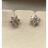 A Pair of 18ct white gold and diamond cluster flower shaped earrings.