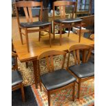 A Danish teak mid century extendable dining table together with 8 matching stylish teak chairs by
