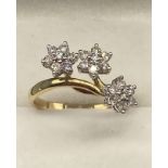 An 18ct gold ladies diamond cluster ring in the shape of three flowers. [3.07grams] [Has been