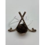A Birmingham silver pin cushion with two golf clubs crossed over.