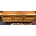 A Mid century Scandinavian style teak 9 drawer sideboard, supported on pedestal legs. [76x196x47cm]