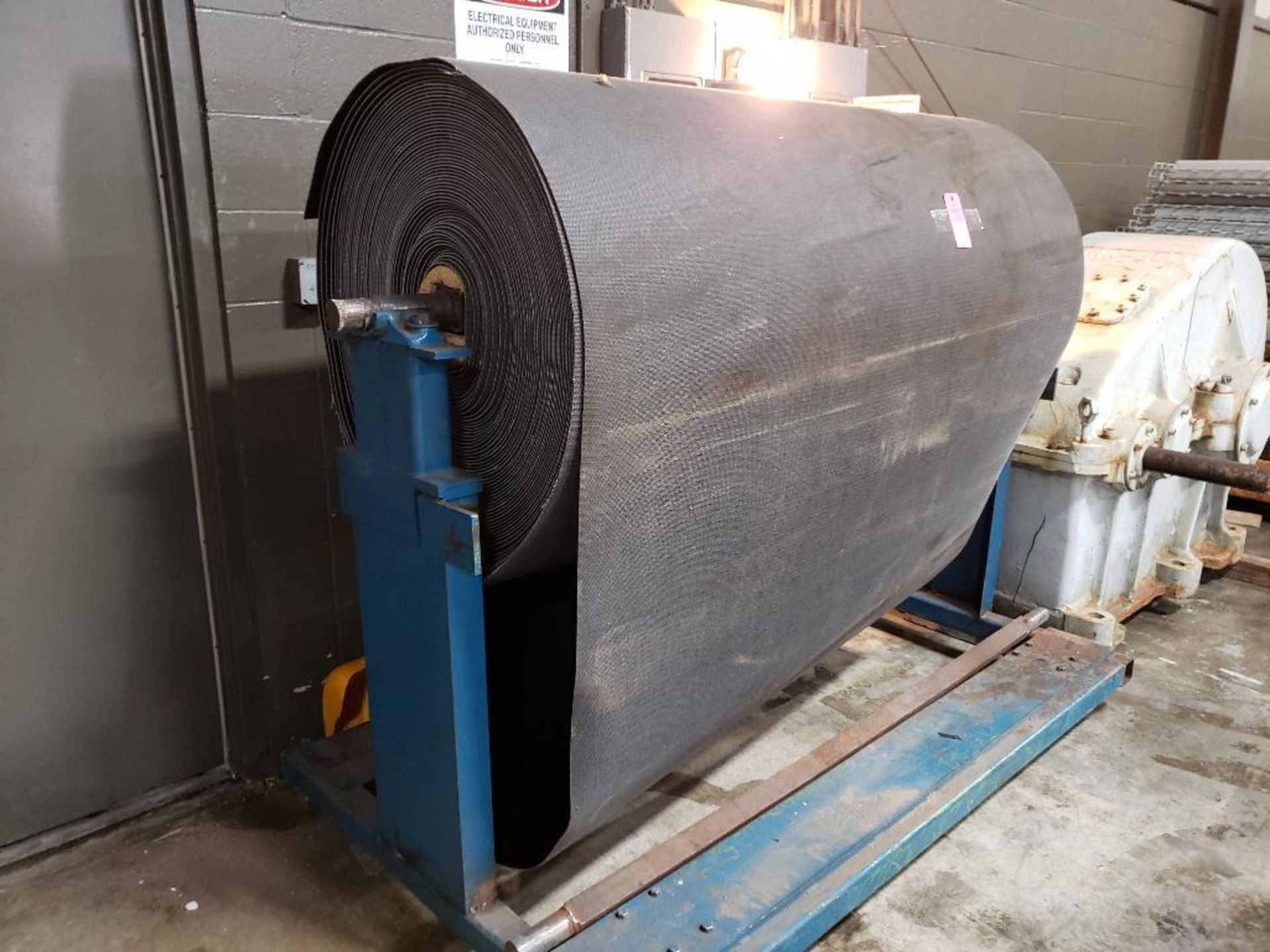 Large roll of conveyor with stand. 66" wide. Roll is approx 32" in diameter.